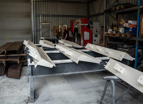 Freshly painted steel members on stands in the paint shop
